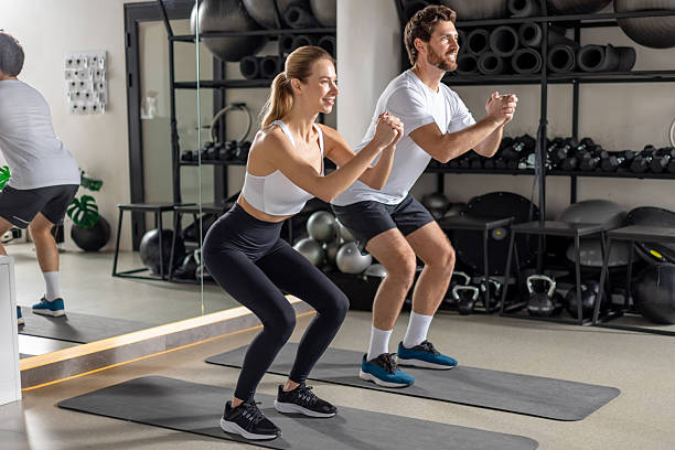 istock Two young people exercising in the gym in squatting position 2252976731