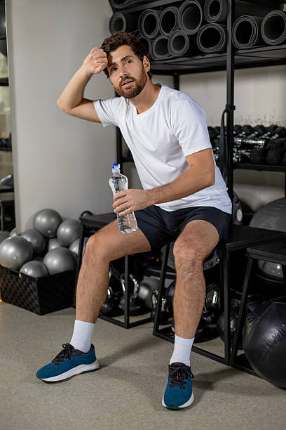 istock Handsome young bearded man in gym resting after workout 2252977042