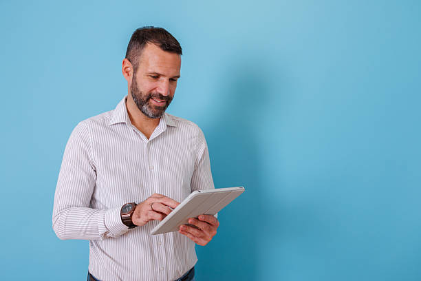 istock Male professional working with a tablet, smiling while engaging in online activities and digital communication 2252983409