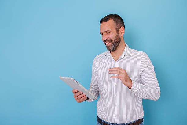 istock Happy man having a video call on a tablet, smiling and communicating remotely for business or casual interaction 2252984127