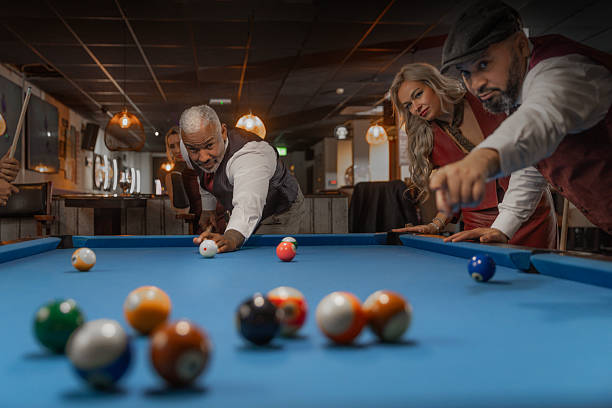 Small group of luxury diverse senior friends enjoying downtime at a pool hall in the Netherlands