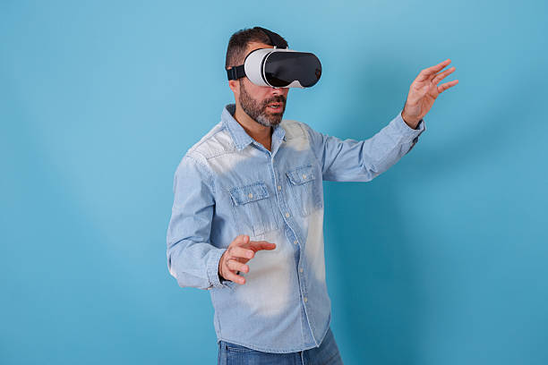 istock Man wearing vr headset making gestures in virtual reality, experiencing metaverse and new technology 2252986554