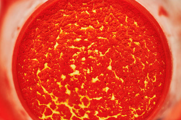 Close-up abstract detail of a textured surface in rich red and yellow tones. Organic patterns and granular texture create a bold visual background suitable for fine art, design, and creative concepts.