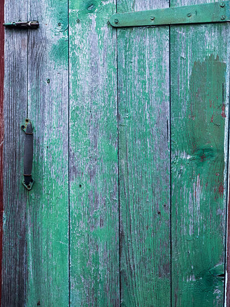 istock Weathered green wooden door texture with peeling paint 2252989775