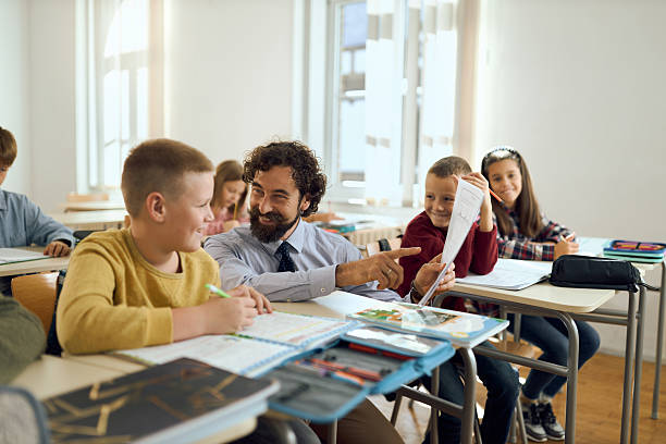 istock Happy schoolboy and his teacher analyzing test results on a class in the classroom 2252992845