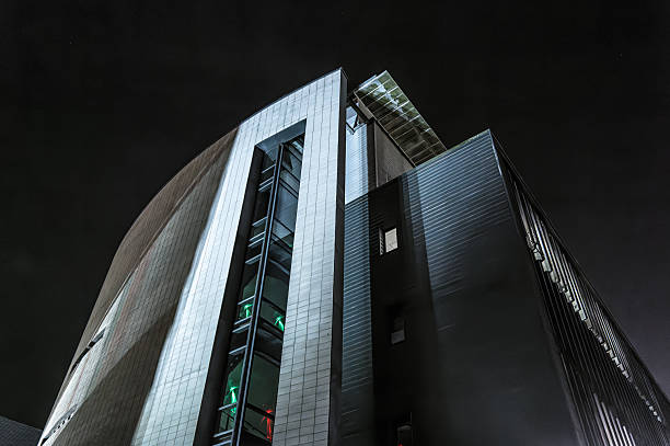 Brutalist designed bio tech building seen during night at a campus in the UK. Seen against an inky black sky.