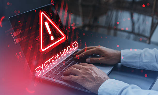 istock Cybersecurity warning alert with red triangle and system hacked message over laptop, highlighting internet virus attack and compromised system data. 2253000636