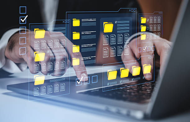 istock Businessman managing digital folders and files through transparent interface on laptop, representing data organization and technology concept. 2253001953