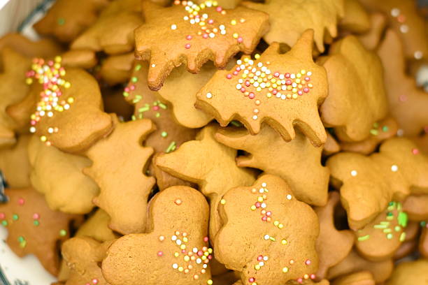 Homemade cookies of different shapes on a plate. Close-up top view showing texture and details.