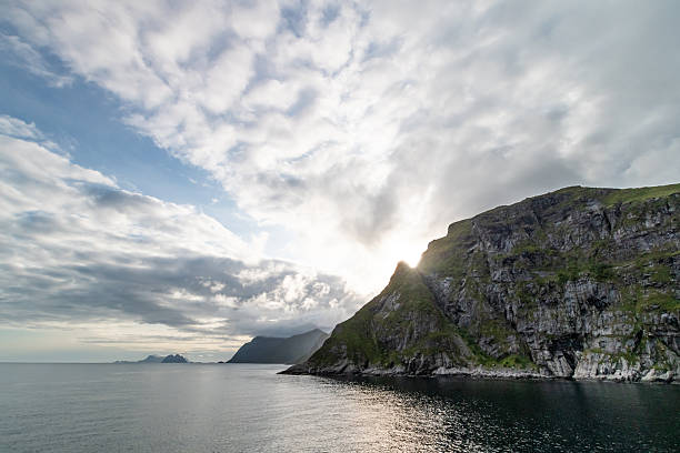 Mountain range by the sea in the Lofoten Islands in Norway during a sunny day of summer near the Reinebringen mountain top.