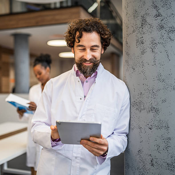 istock Male doctor scientist using digital tablet smiling 2253008376