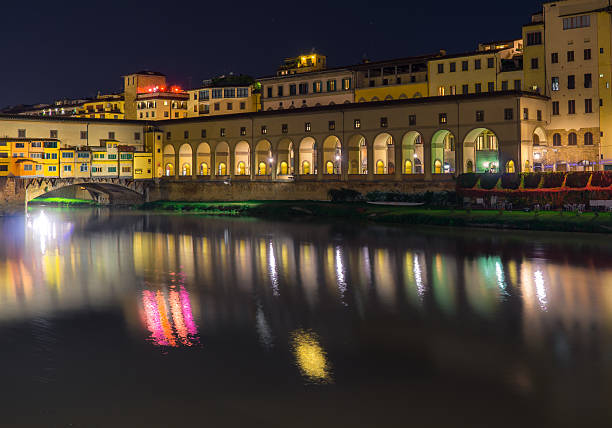 Florence, Italy - September 07, 2022: People at the Lungarno degli Archibusieri at night. In the background, Ponte Vecchio, the symbol of the city.