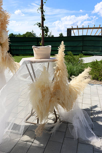 istock Boho outdoor table decor with pampas grass, airy fabric and basket in garden setting, elegant wedding or event styling 2253022400