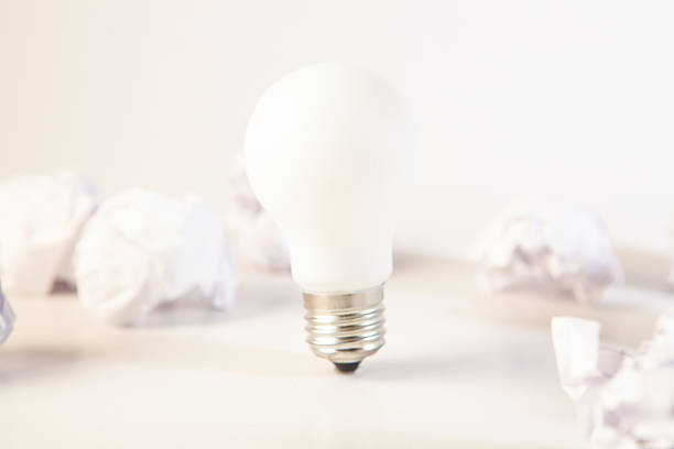 istock Incandescent light bulb with crumpled paper on white background 2253024012