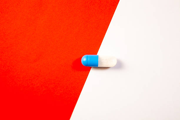 istock Blue and white pill on a red and white background. Medicine concept. 2253024024