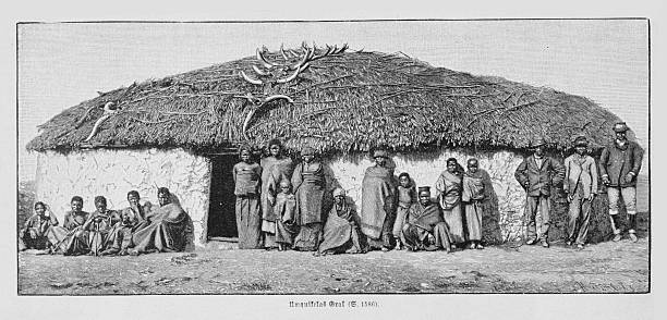 19th-century engraving depicting an African kraal with a group of local inhabitants gathered in front of a traditional thatched hut, accompanied by European visitors, illustrating ethnographic life and colonial-era travel observation.