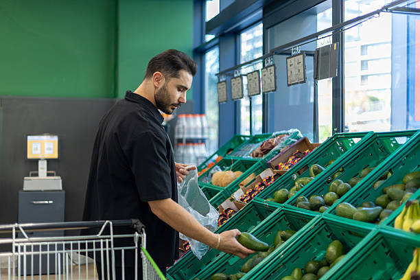 istock Man selecting fresh avocado at grocery store produce section 2253026573