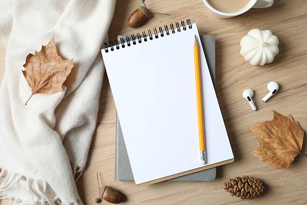 istock Wooden table with notebook, pencil, scarf and coffee cup, top view 2253031794