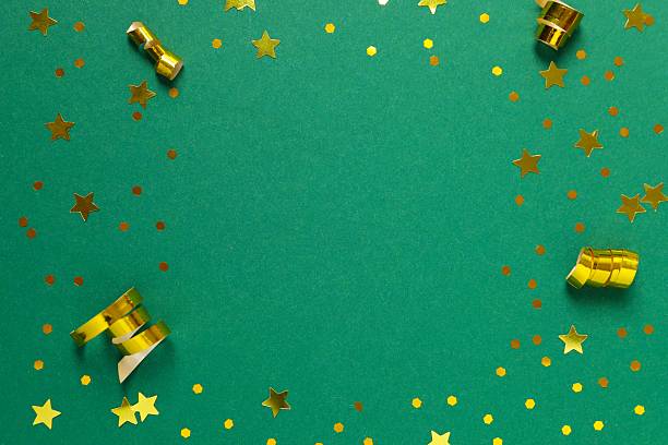Golden confetti on green background, top view