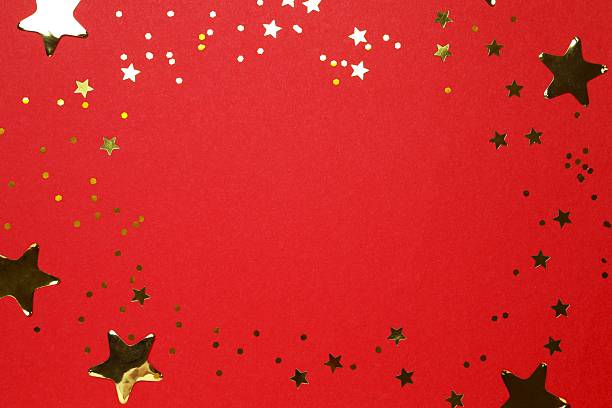 Golden confetti on red background, top view