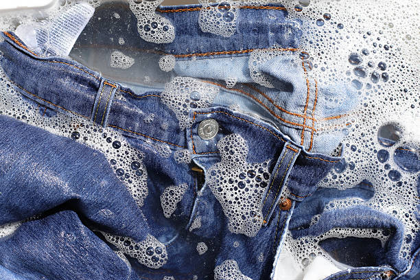 istock A pair of blue denim jeans soaking in soapy water, creating a layer of foam. 2253033446