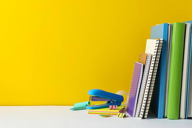 istock Colorful and modern workspace with stationery and notebooks and yellow wall 2253033819