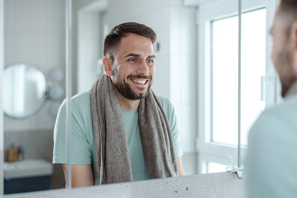 istock Man in bathroom during morning routine, looking at the mirror, practicing self-care 2253034565