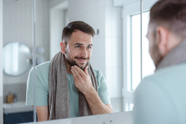 istock Man in bathroom during morning routine, looking at the mirror, practicing self-care 2253034569