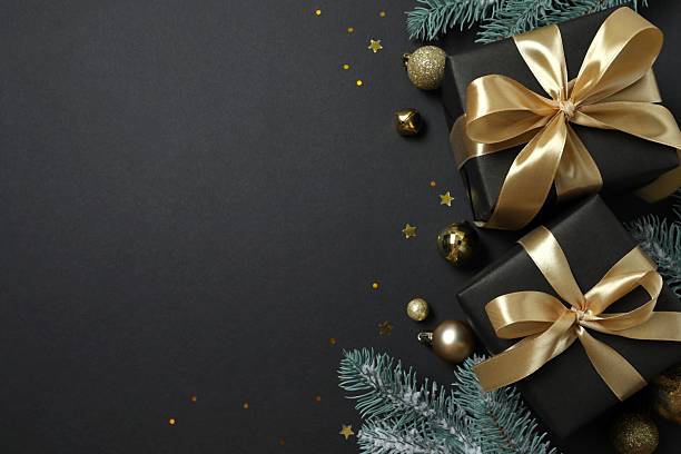 istock Beautiful gift boxes tied with bows and Christmas decorations on black background 2253035042