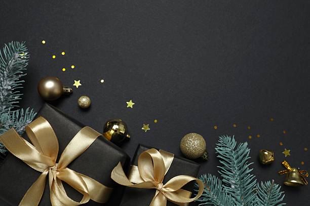 istock Beautiful gift boxes tied with bows and Christmas decorations on black background 2253036019