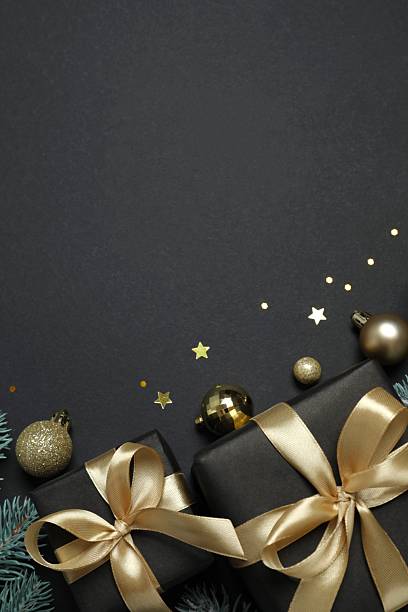 istock Beautiful gift boxes tied with bows and Christmas decorations on black background 2253036027
