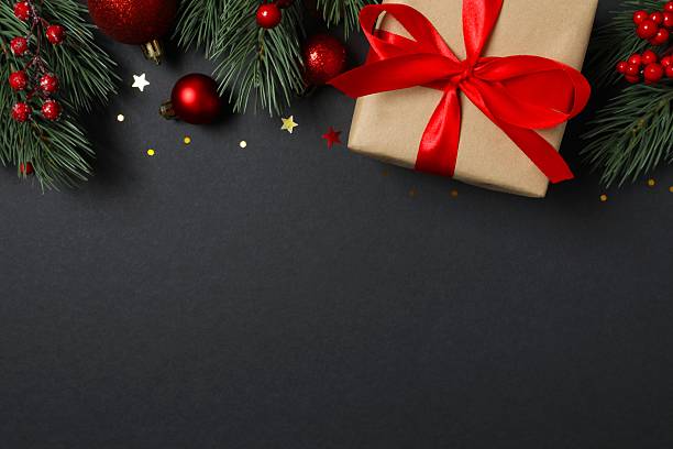 istock Beautiful gift box tied with bow and Christmas decorations on black background 2253036469