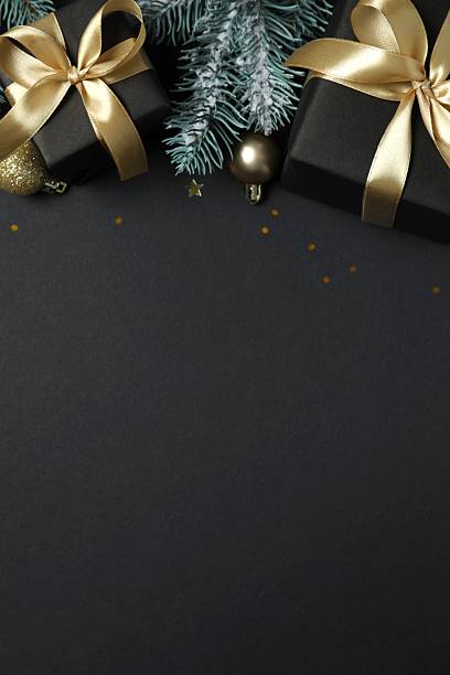 istock Beautiful gift boxes tied with bows and Christmas decorations on black background 2253036470
