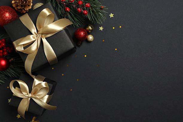 istock Beautiful gift boxes tied with bows and Christmas decorations on black background 2253036492