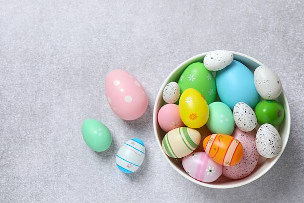 istock Happy Easter. Colorful eggs in a bowl on color background, space for text or advertising 2253037416