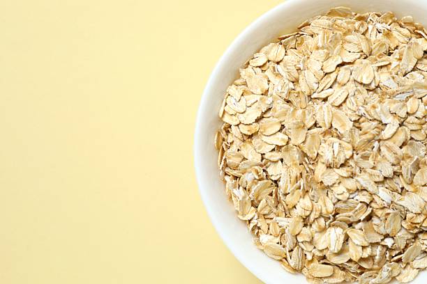 istock Composition with oatmeal flakes on gray background. Cooking breakfast 2253037436