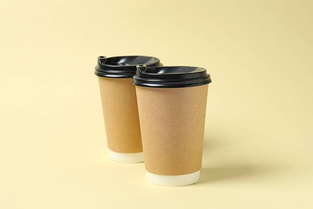 istock Paper cups of coffee on beige background 2253039029