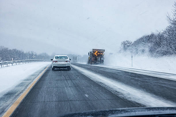 istock Traffic Passing Working Snow Plow Truck During Winter Snow Blizzard 2253041485
