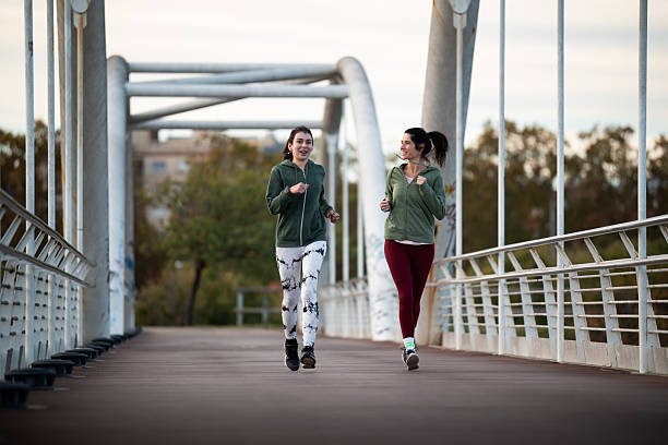 istock Two women friends jogging on a bridge 2253041626