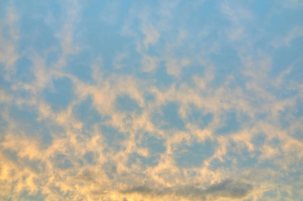 Sunset with unusual orange clouds and blue sky background, full frame