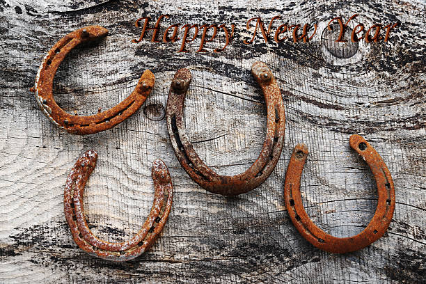Four old rusty horseshoes on a wooden base
