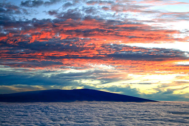 This is a view south from Mauna Kea showing the profile of Mauna Loa. It shows an unusual mixture of low-lying clouds brought in by the trade winds and high clouds from a weather front moving in from the north.