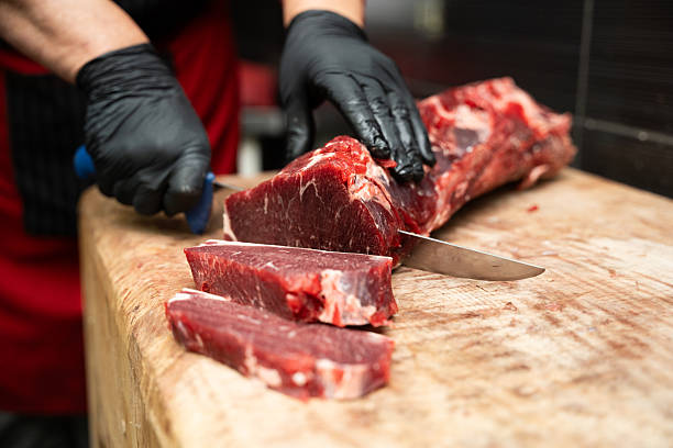 istock Professional meat preparation in butcher shop kitchen. 2253049366