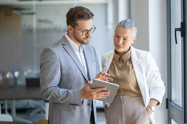 istock Business colleagues using tablet and discussing work in office 2253051033