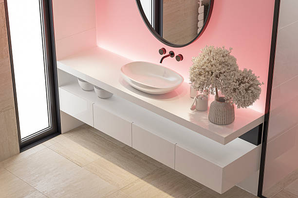 istock Stylish Bathroom with Pink Accent Back Lit Wall and Round Mirror 2253054562