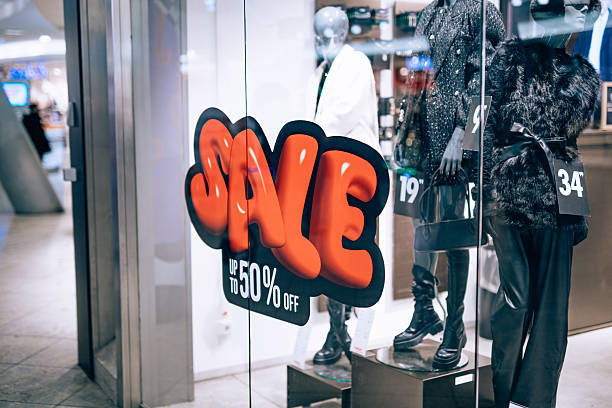 istock Store window display with mannequins and bold sale sticker 2253057571