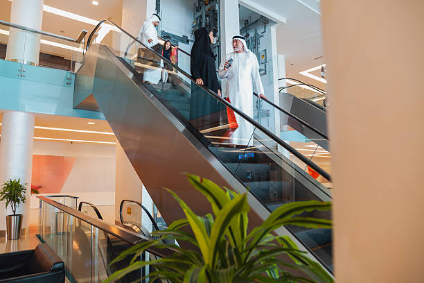 istock Modern shopping mall interior with Middle Eastern family using escalator and spending time together in a luxury retail environment with copy space 2253058332