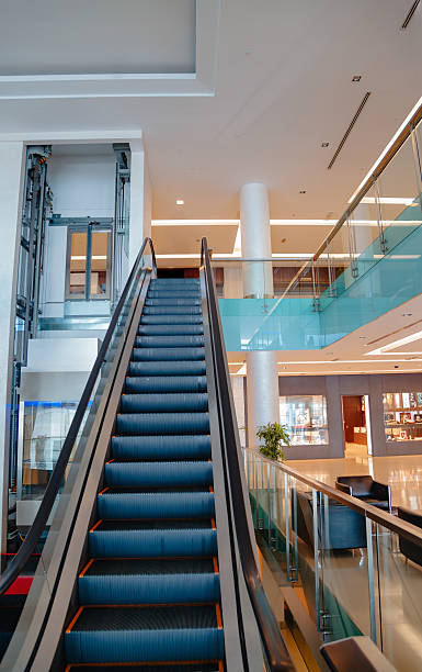 istock Empty modern shopping mall interior with escalator and glass railing blank copy space area 2253058338