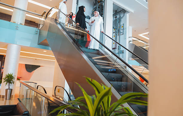 istock Modern shopping mall interior with Middle Eastern family using escalator and spending time together in a luxury retail environment with copy space 2253058355