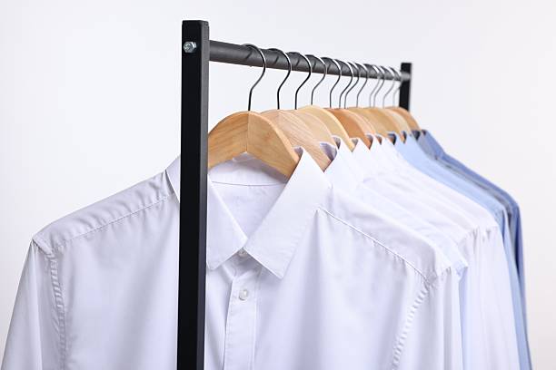 istock Dry-cleaning service. Many different clothes hanging on rack against white background, closeup 2253059779
